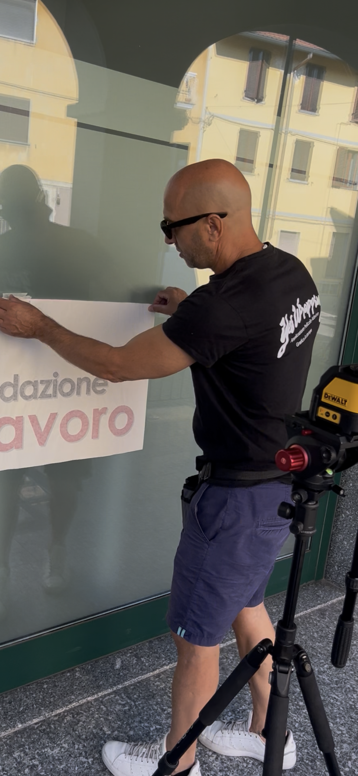 Tecnico YesWrapping durante l’applicazione di una vetrofania personalizzata su una vetrina commerciale.